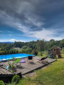 una terraza de madera con sillas y una piscina en Gospodarstwo Gościnne Księżycówka, en Rajbrot