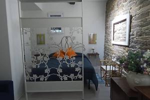 1 dormitorio con 1 cama con sábanas azules y almohadas de color naranja en La casa di Nina, en Pulicciano