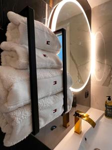 a bathroom with a stack of towels in a mirror at Palais 5min Luxury&Cinema Studio in Cannes