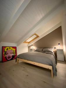 1 dormitorio con 1 cama grande en el ático en Casa di Nuvola -Residenza Lavinia -, en Monforte dʼAlba