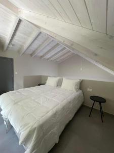 a large white bed in a room with a ceiling at Myrtia Villas I in Anomeriá