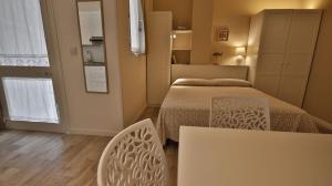 a bedroom with a bed and a table and chair at Casa Levante a 75 mt dalla spiaggia in Monopoli