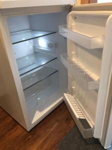 an open refrigerator with its door open and its shelves at Ferienwohnung Sonne in Schliengen