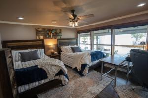een slaapkamer met 2 bedden en een plafondventilator bij Luxury Waterfront Lakehouse Retreat - Piney Woods of East Texas - Lake Palestine in Chandler