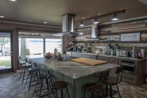 een keuken met een groot eiland met barkrukken bij Luxury Waterfront Lakehouse Retreat - Piney Woods of East Texas - Lake Palestine in Chandler