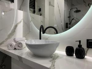 W łazience znajduje się umywalka i lustro. w obiekcie ALLURE PREMIUM APARTMENT w mieście Lublin