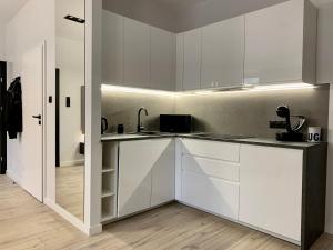 a kitchen with white cabinets and a sink at ALLURE PREMIUM APARTMENT in Lublin