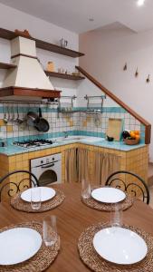een keuken met een houten tafel met borden erop bij Casa Curu in Sciacca