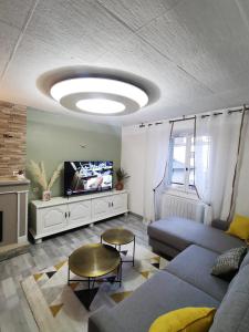 a living room with a couch and a tv at Rodez centre ville, Parking gratuit in Rodez