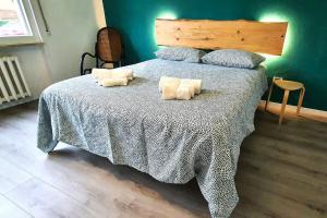 een slaapkamer met een groot bed met een blauwe muur bij Eco Villetta di Beppina con giardino - Self Check-in in Pratovecchio