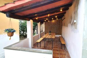 een patio met een houten tafel en banken in een gebouw bij Eco Villetta di Beppina con giardino - Self Check-in in Pratovecchio