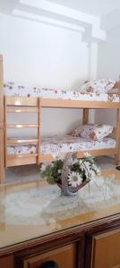 two bunk beds in a room with flowers on a table at Villa Karolina in Ohrid