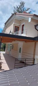 Dieses weiße Haus verfügt über einen Balkon und eine Veranda. in der Unterkunft Karolina Guest House in Ohrid
