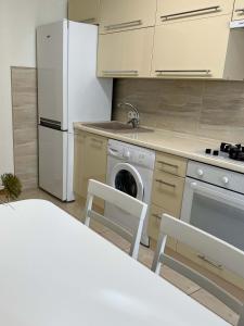 a kitchen with a white refrigerator and a dishwasher at New Apartment "Family Estate" in Kamianets-Podilskyi