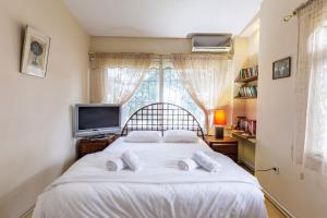 una camera da letto con un letto con lenzuola bianche e una TV di Uniq a Istanbul
