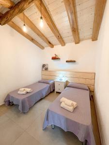 2 letti in una camera con soffitti in legno di Tanca Noa a Tortolì