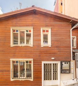 una casa de madera con ventanas blancas. en Historical Duplex Villa with Patio in Beyoglu, en Estambul