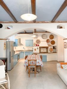una cucina e una sala da pranzo con tavolo e sedie di Tanca Noa a Tortolì