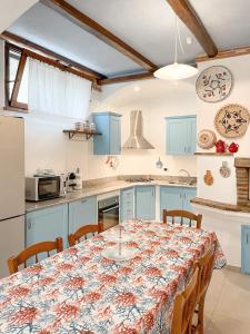 トルトリにあるTanca Noaのキッチン(青いキャビネット、テーブル、椅子付)