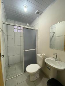 a bathroom with a toilet and a shower and a sink at Nova Pousada Consulado in Ponta Grossa