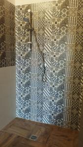 巨塔的住宿－casa vacanza Il Delfino，带淋浴的浴室(带瓷砖墙)