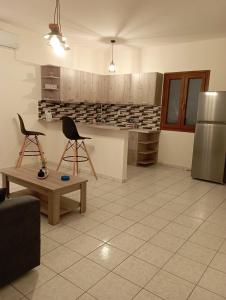 a kitchen with two chairs and a table and a refrigerator at Sofirene II in Batsi