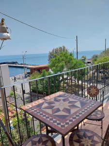 a table and chairs on a balcony overlooking the ocean at La casa in piazzetta in Riposto