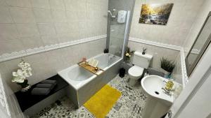 een badkamer met een bad, een toilet en een wastafel bij Stylish & Cosy - Flat 6, Osborne Road in Pontypool