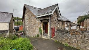 an old stone building with a red door at Stylish & Cosy - Flat 6, Osborne Road in Pontypool