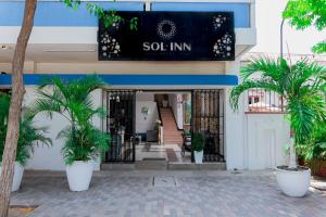 un accès à un bâtiment avec des palmiers devant lui dans l'établissement Hotel Sol Inn Santa Marta, à Santa Marta
