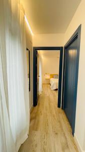 Apartamentos BRAVO MURILLO con garaje en centro histórico في بطليوس: ممر به غرفة بها سرير وغرفة بها