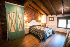 1 dormitorio con cama y puerta verde en Apartamentos A Fala en Trevejo y San Martin de Trevejo, Sierra de Gata, en Trevejo
