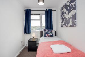 Schlafzimmer mit einem Bett und einem Fenster mit blauen Vorhängen in der Unterkunft TMS Lovely 3 bedroom house! Free parking!Free WiFi! in Low Street