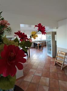 un soggiorno con fiori rossi in un vaso di Hôtel Les Calanques a Les Issambres