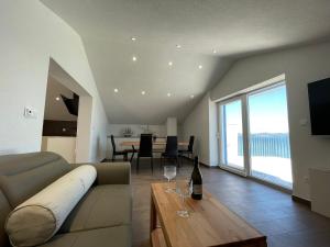 BEACHFRONT VILLA Murter في مورتير: غرفة معيشة مع أريكة وطاولة مع كؤوس للنبيذ