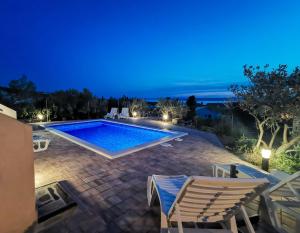 Villa con piscina por la noche en Apartments Durdica F, en Punat