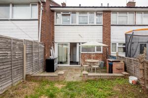 a patio with a table and an umbrella in front of a house at TMS Lovely 3 bedroom house! Free parking!Free WiFi! in Low Street