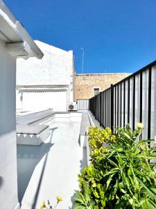 un balcón con bancos y plantas en un edificio en Saint Patrick Guest House, en Barletta