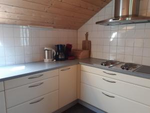 a small kitchen with white cabinets and a stove at Rosanna in Egg
