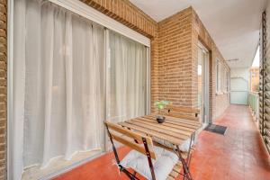 d'un balcon avec une table en bois et un banc. dans l'établissement CasaCafé Madrid Pozuelo 2 Baño Fuera de la habitacion o COMPARTIDO, à Pozuelo de Alarcón