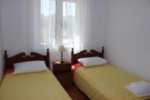 two beds sitting next to each other in a room with windows at TOTEM Sea View Apartment in Plaka