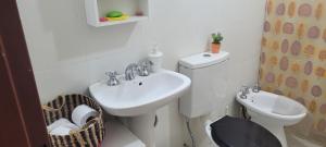 Un baño blanco con lavabo e inodoro. en OASIS I Las Moras con cochera y jardín, en La Rioja 17 fotos más
