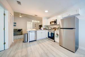 a kitchen with white cabinets and a stainless steel refrigerator at Lagoon 2623 by Nautical Properties in Panama City Beach
