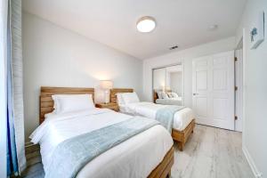 two beds in a bedroom with white walls at Lagoon 2623 by Nautical Properties in Panama City Beach