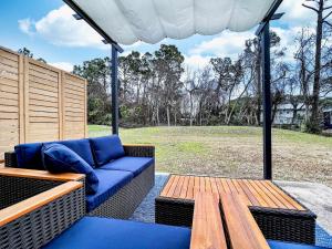 a patio with a blue couch and a wooden table at Lagoon 2623 by Nautical Properties in Panama City Beach