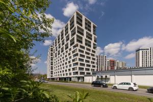 a tall white building with cars parked in front of it at City Centre & Modern Apartment with Parking by Renters Prestige in Krakow