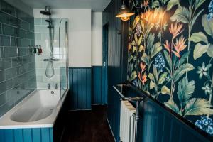 a bathroom with blue tiles and a tub at The Corner House Canterbury in Canterbury