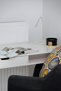 a white desk with a chair and a book on it at City Centre & Modern Apartment with Parking by Renters Prestige in Krakow