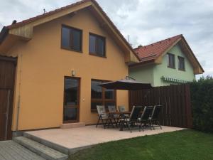 ein Haus mit einer Terrasse mit Stühlen und einem Sonnenschirm in der Unterkunft Casa Maika in Frymburk