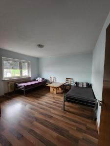 Cette chambre comprend 2 lits et une table. dans l'établissement Stadthostel, à Töging am Inn